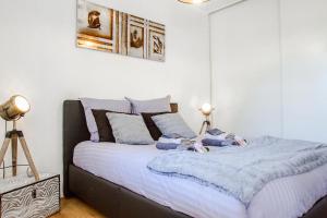 ein Schlafzimmer mit einem Bett mit blauen Decken und Kissen in der Unterkunft Séjour Toulouse Purpan Le D'este in Toulouse