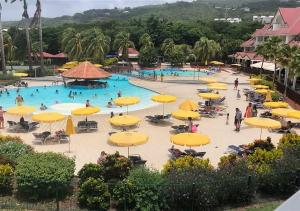 a large pool with yellow umbrellas and people in it at Appartement 2 à 6 personnes dans un magnifique complexe de Vacances à Sainte-Luce in Sainte-Luce