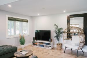 a living room with a tv and a chair at Sandbanks Cottage on Sheba's Island - 5 min drive, pet friendly in West Lake