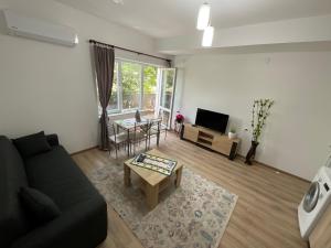 a living room with a couch and a table at Апартаменти за Гости-Фотинова Попово in Bŭnzareto