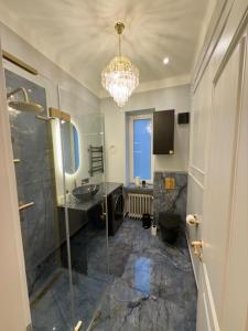 a bathroom with a sink and a chandelier at KR Apartment Kaunas in Kaunas