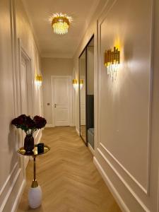 a hallway with a vase of flowers on a table at KR Apartment Kaunas in Kaunas +2 photos
