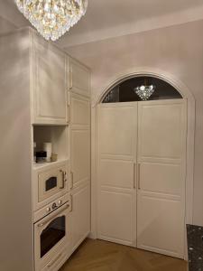 a kitchen with a white cabinet and a microwave at KR Apartment Kaunas in Kaunas