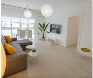Una sala de estar blanca con un sofá y un televisor. en Granada Eye, en Granada