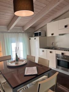 a kitchen with a wooden table and chairs and a dining room at Residence Del Lago in Desenzano del Garda