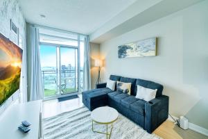 a living room with a couch and a large window at RivetStays - The Parade 2 in Toronto