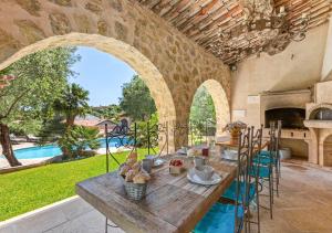 ein Esszimmer im Freien mit einem Tisch und einem Pool in der Unterkunft Villa provençale calme avec piscine chauffée 6 ch in Le Rouret
