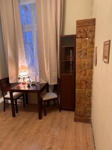 a room with a desk and a table and a window at Enios Rooms Hostel Zwierzyniecka 6 in Kraków