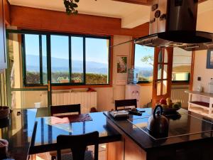 a kitchen with a large window and a counter with chairs at Casa Paz in Nigrán