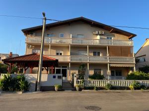 duży budynek apartamentowy z dużym balkonem w obiekcie Apartmani Italo w Biogradzie na Moru