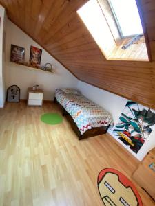 Zimmer im Dachgeschoss mit einem Bett und einem Fenster in der Unterkunft MAISON FAMILIALE ENTRE MER ET MONTAGNE Lisbonne in São Bartolomeu