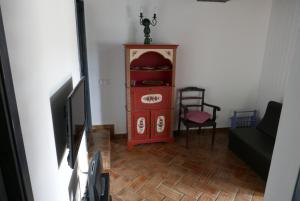 a living room with a red cabinet and a chair at Barranco do Zambujeiro in Vila do Bispo