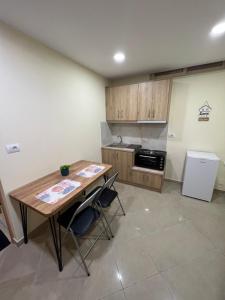 a kitchen with a wooden table and a refrigerator at Saranda View Apartments in Sarandë