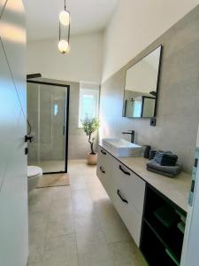 a bathroom with a sink and a toilet and a mirror at Villa Ankica in Tribunj +95 photos