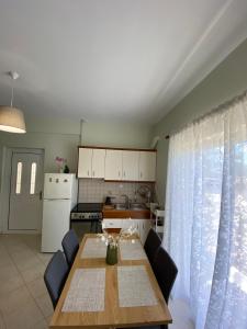 a kitchen with a wooden table and a kitchen with a table and chairs at Rodia apartment in Kyparissia