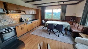 a kitchen with a table and a couch at Olmhaus mit Sauna und E-Bikes in Obergösel