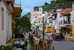 a group of people sitting at tables on a city street at Rodia apartment in Kyparissia