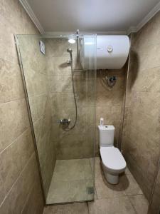 a bathroom with a shower and a toilet with a glass door at Saranda View Apartments in Sarandë +20 photos