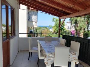 a table and chairs on the balcony of a house at kadınlar denizi plaji 100 m bahceli havuzlu in Kusadası