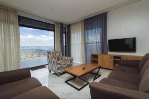キガリにあるISUITE Apartmentsのリビングルーム(テレビ、ソファ、椅子付)