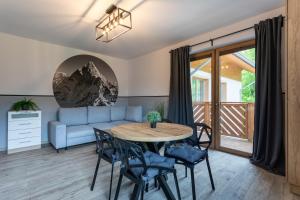 un salon avec une table, des chaises et un canapé dans l'établissement Bawaria w Dolinie Szczęścia, à Szklarska Poręba