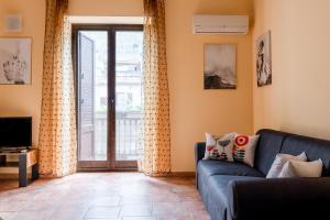 a living room with a blue couch and a window at casa Fontana in Capaci