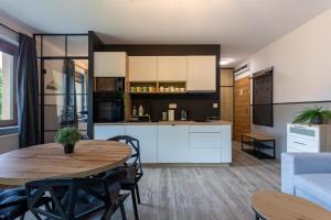 une cuisine et un salon avec une table et des chaises dans l'établissement Bawaria w Dolinie Szczęścia, à Szklarska Poręba 16 autres photos