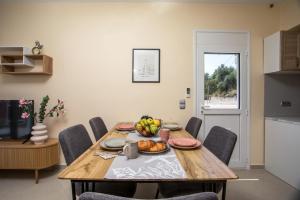 a dining room table with a bowl of fruit on it at Palmtrees Apartments in Afantou