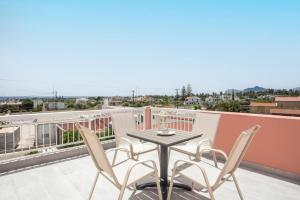 a table and chairs on a balcony with a view at Palmtrees Apartments in Afantou