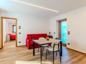 a living room with a table and a red couch at Apartment Martin Pescatore by Interhome in Verceia +22 photos