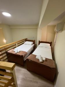 two beds in a small room with a lamp at Saranda View Apartments in Sarandë
