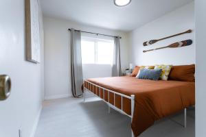 オーシャンサイドにあるKing Suite - 2min Walk to Beach Close to Downtown!のベッドルーム1室(オレンジのシーツが入ったベッド1台、窓付)