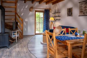 a living room with a wooden table and a staircase at Słowicze Gniazdo Kopalino in Kopalino