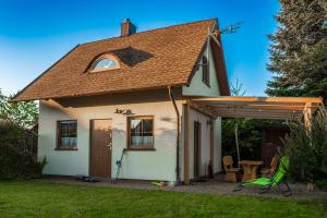 une petite maison blanche avec un toit en pente dans l'établissement Słowicze Gniazdo Kopalino, à Kopalino