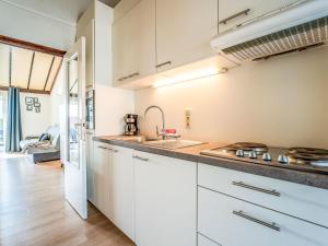 a kitchen with white cabinets and a sink at Apartment Zeewind II A 11 by Interhome in Bredene