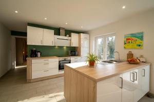 a kitchen with white cabinets and a counter top at Chez Bertine Gîte rural 3 épis in Sivry