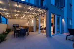 a patio with a table and chairs with lights on it at Apartman Pax in Podstrana