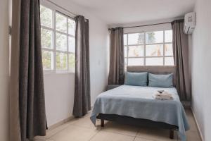 ein Schlafzimmer mit einem Bett und zwei Fenstern in der Unterkunft Casa Ferlioni in Temixco + 41 Fotos