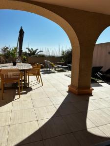 a patio with a table and chairs and an umbrella at CAP AU SUD in Hyères