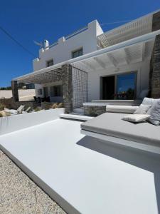 a white villa with a view of the ocean at Neso seafront studio Paros in Parasporos +25 photos