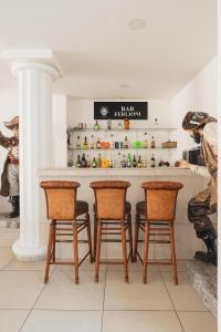 eine Küche mit einer Bar mit 4 Stühlen und einer Theke in der Unterkunft Casa Ferlioni in Temixco