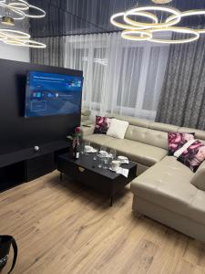 Una sala de estar con un sofá y un televisor de pantalla plana. en Sapore Dream STUDIO 3, en Opole