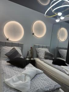 2 camas en un dormitorio con espejos en la pared en Sapore Dream STUDIO 3, en Opole