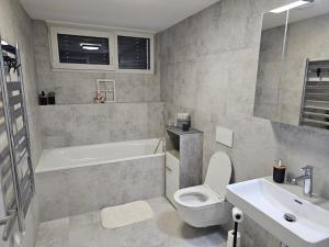 a bathroom with a toilet and a tub and a sink at Sun Prague - Stodůlky in Prague +22 photos