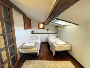 two beds in a small room with a window at Vistalaguna Orbetello in Orbetello