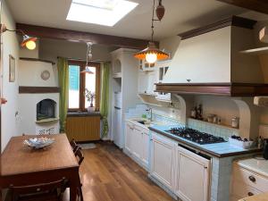 a kitchen with white cabinets and a wooden table at Vistalaguna Orbetello in Orbetello