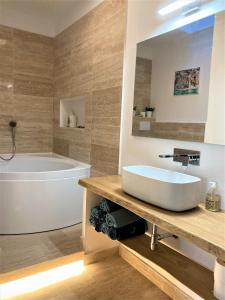a bathroom with a tub and a sink and a bath tub at Vistalaguna Orbetello in Orbetello +16 photos