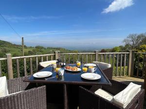 a table with plates of food on a balcony with a view at 2 Bed in Abergavenny 83894 in Llanover