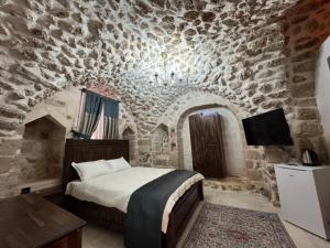 a bedroom with a bed and a stone wall at History Palace Otel in Mardin