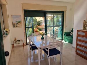a dining room with a table and chairs and a couch at Casa Alessia Taormina in Taormina